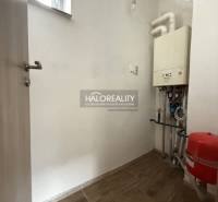 Technikraum in einem Einfamilienhaus mit einem Kessel und einem Boden mit Holzdekor.