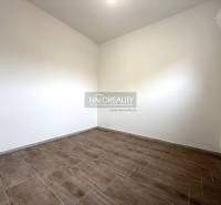 Ein Zimmer mit Holzboden in einem Einfamilienhaus, helle Wände, Heizkörper.