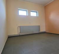 Innenraum von Lagern und Hallen mit Fliesenboden und Heizkörper unter einem Paar Fenstern.