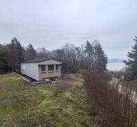 Ein Ferienhaus in der Hauptstraße in Nová Kelča mit Blick auf die Wasserfläche und den Wald.