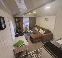 Interieur der Hütte mit Sofa, Esstisch und ausgestatteter Küche.