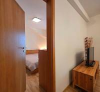 Ferienwohnung mit Holzboden, Blick auf das Schlafzimmer und die Wohnwand.