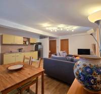 Wohnzimmer mit Küchenzeile in einer Ferienwohnung, Boden mit Holzdekor.