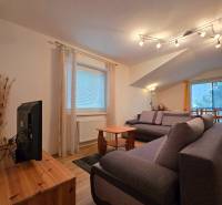 Wohnzimmer in der Ferienwohnung mit bequemen Sofas und Holzboden.