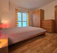 Schlafzimmer in einer Ferienwohnung mit Holzboden, Bett und Schrank.