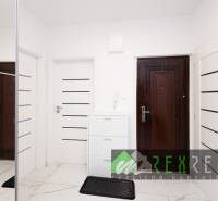 Der Flur mit weißen Türen und einem Spiegelschrank in einer 3-Zimmer-Wohnung.