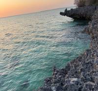Küstenklippen und Sonnenuntergang über sanften Meereswellen in Kizimkazi, Grundstücke - Gewerbe.