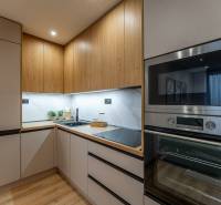 Küche in einer 2-Zimmer-Wohnung mit Holzboden, Holzschränken und Geräten.