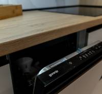 In der Küche der Zweizimmerwohnung befindet sich ein Geschirrspüler von Gorenje und ein Boden mit Holzdekor.
