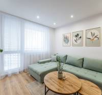 Wohnzimmer in einer 2-Zimmer-Wohnung mit Sofa, Bildern und Holzboden.