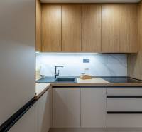 Küche mit Holzboden und eingebauten Geräten in einer 2-Zimmer-Wohnung.