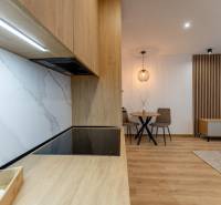 Küche in einer 2-Zimmer-Wohnung mit Arbeitsplatte und Boden in Holzoptik.