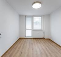 Ein Zimmer in einer 3-Zimmer-Wohnung mit einem Holzboden und einem großen Fenster.