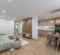 Wohnzimmer mit Küche in einer 3-Zimmer-Wohnung, Boden mit Holzdekor, stilvolle Beleuchtung.