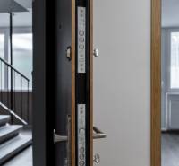 Eine offene Tür zu einer 3-Zimmer-Wohnung, man sieht einen Boden mit Holzdekor und ein Fenster.