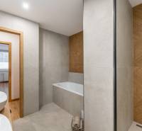 Badezimmer in einer 3-Zimmer-Wohnung mit Badewanne und Doppelwaschbecken, Boden mit Holzdekor.