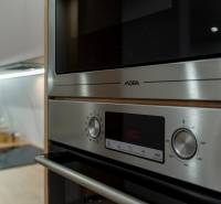 Küchenzeile in einer 3-Zimmer-Wohnung mit Edelstahl-Backofen und Mikrowelle.