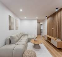 Wohnzimmer in einer 3-Zimmer-Wohnung mit einem Sofa und einem Boden in Holzoptik.