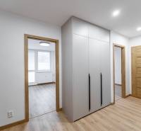 Flur in einer 3-Zimmer-Wohnung mit Holzboden, Schrank und Innentüren.