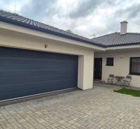 Ein Einfamilienhaus in Studienka mit zwei Stühlen und einem Tisch auf dem gepflasterten Hof.