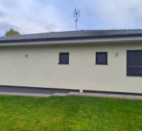 Ein Einfamilienhaus in Studienka mit Terrasse, grünem Rasen und moderner Fassade.