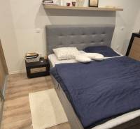 Schlafzimmer mit Holzboden, Bett und Stauraum in einem Einfamilienhaus.