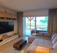 Wohnzimmer eines Einfamilienhauses mit Sofa, großem Fernseher und Holzboden.