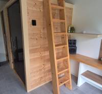 Innenraum eines Einfamilienhauses mit Holzsauna, Leiter und Stereoanlage.