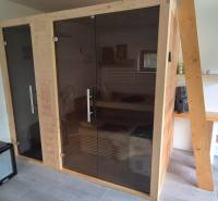 Innenraum eines Einfamilienhauses mit Sauna, Ventilator und Waschbecken auf einem Holztisch.