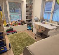 Kinderzimmer in einem Einfamilienhaus mit Spielzeug, Tisch und Boden in Holzoptik.