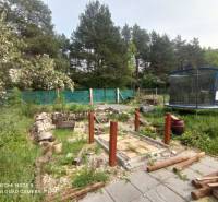 Der Garten bei der Hütte in Hliník nad Hronom mit einem Trampolin und einem Holzweg.