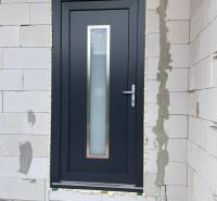 Eingangstür eines Einfamilienhauses in Radava, umgeben von Ziegelmauerwerk.