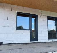 Unvollendete Fassade eines Einfamilienhauses in Radava mit Kunststofftüren und -fenstern.