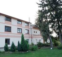 Das Gebäude des Hotels und der Pension in Poľný Kesov, umgeben von Grün und Bäumen.