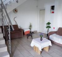 Innenraum mit Sofa, Tisch, Pflanzen und Treppen in Hotels und Pensionen.