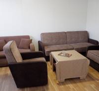 Wohnzimmer mit Sofas, Sesseln, einem Tisch und einem Boden mit Holzdekor in Hotels und Pensionen.