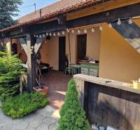 Ein Einfamilienhaus in Dlhá nad Váhom mit Terrasse, Holzelementen und Gartendekoration.