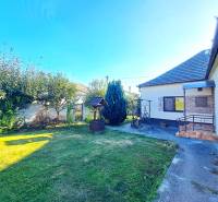 Ein Einfamilienhaus in Neded mit einem gepflegten Garten, Rasen und einem Pavillon neben dem Haus.