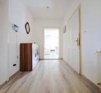 Ein Flur in einem Einfamilienhaus mit einem Boden in Holzoptik und weißen Wänden.