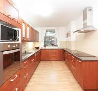 Küche in einem Einfamilienhaus mit Holzdekor, mit Kochfeld und Mikrowelle.