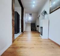 Innenraum eines Einfamilienhauses mit Holzboden und Treppe im Hintergrund.