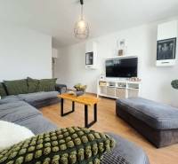 Wohnzimmer in einem Einfamilienhaus mit Holzboden und bequemer Sitzgarnitur.