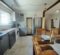 Eine Küche in einem Einfamilienhaus mit einem Holztisch und modernen Geräten.