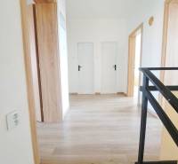 Innenraum eines Einfamilienhauses mit Holzboden und weißen Türen.