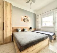 Helles Schlafzimmer mit Holzmöbeln, Doppelbett und Bild in einer Ferienwohnung.