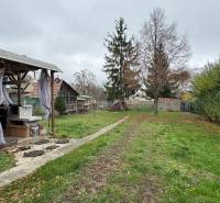 Der Garten beim Einfamilienhaus in Čechynce mit Pavillon und Gehweg, umgeben von Grün.