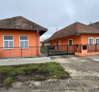 Ein Einfamilienhaus in Čechynce mit einer orangefarbenen Fassade und einem Ziegeldach.