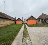 Ein Einfamilienhaus in Čechynce mit Garten, Betonweg und Kiesparkplatz.