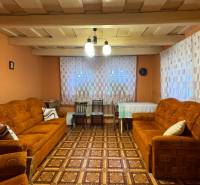 Wohnzimmer in einem Einfamilienhaus mit orangefarbenen Sofas und einem Boden in Holzoptik.