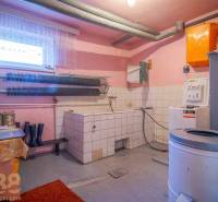 Waschküche in einem Einfamilienhaus mit Waschmaschine, Trockner und Stauraum.